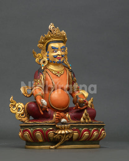 Dzambhala statue seated on detailed lotus throne.