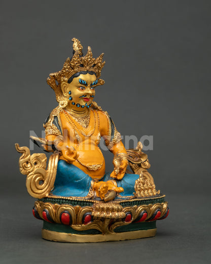 Dzambhala statue seated on hand carved lotus pedestal while holding citron fruit.