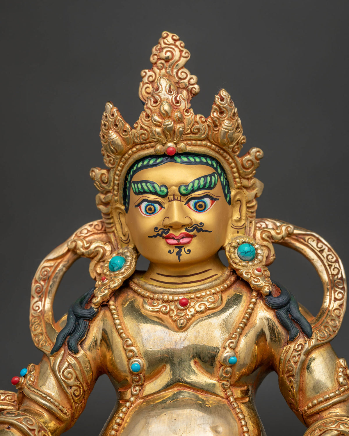 Dzambhala statue semi wrathful face semi precious stones gold painted.