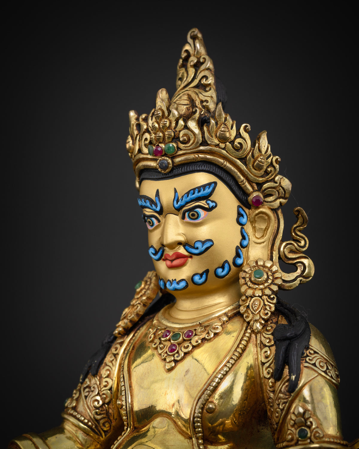 Dzambhala Statue side face close up, gold painted profile, handcrafted Buddhist wealth deity