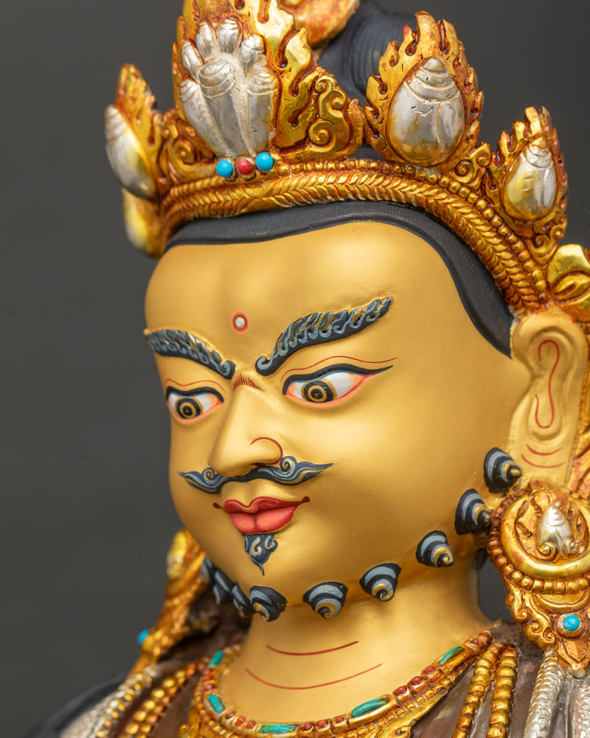 Dzambhala Statue side profile of gold-painted face with jeweled crown and turquoise-inlaid halo