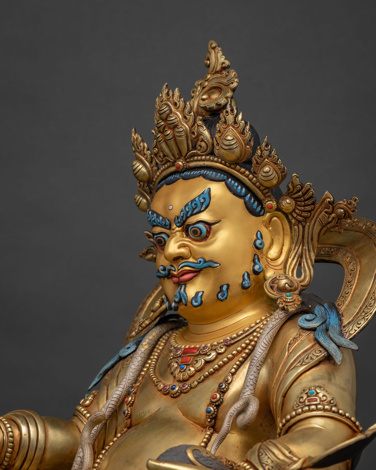 Dzambhala Statue upper body view in dramatic dark lighting