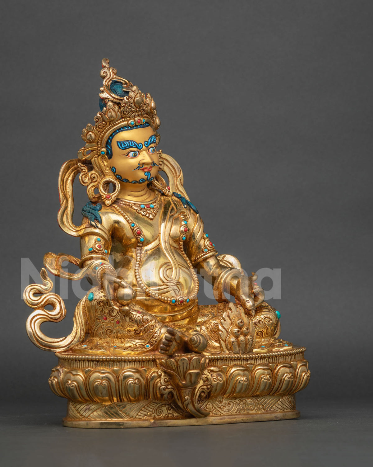 Dzambhala statue with semi precious stones and floral silk garment.