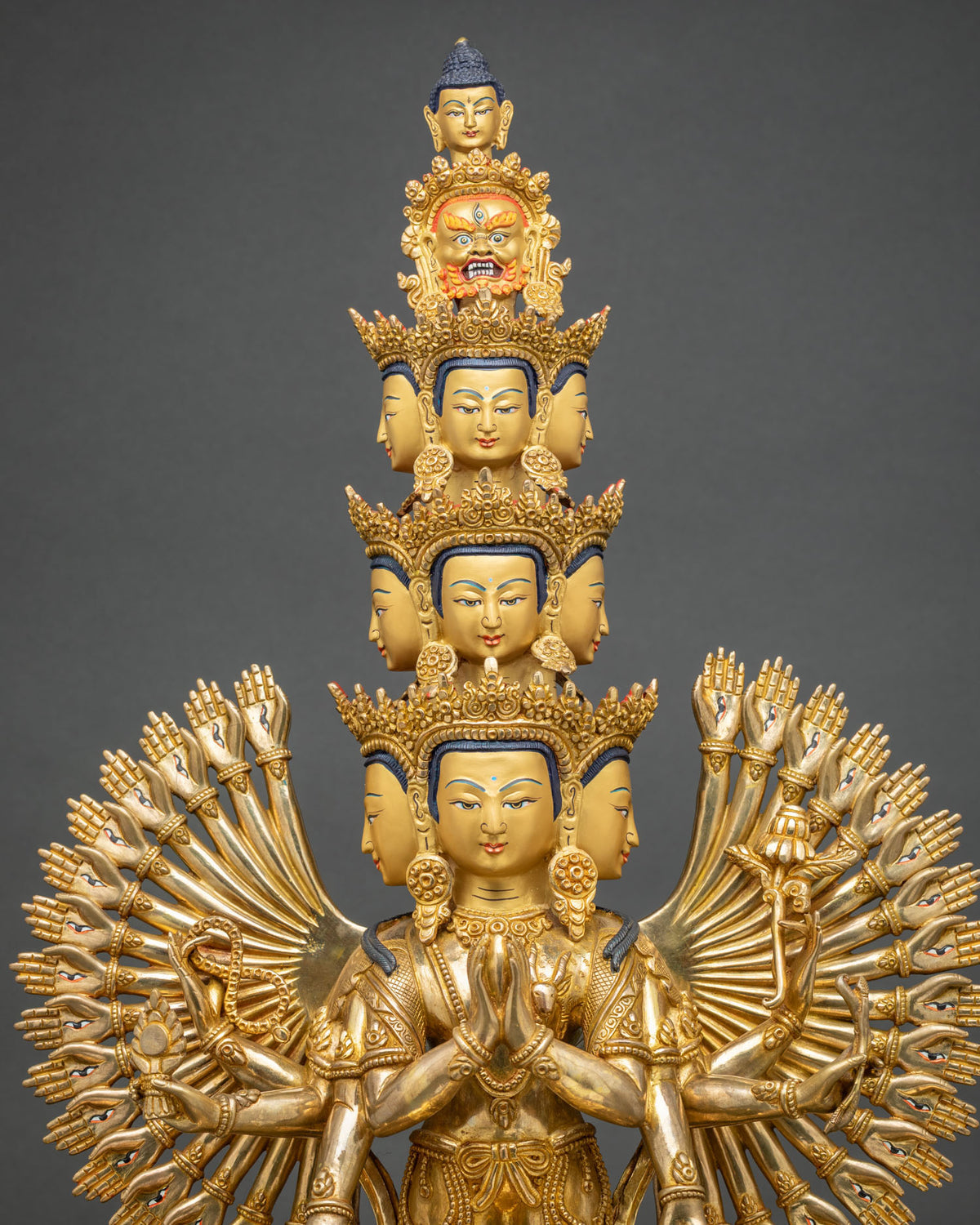Eleven-headed 1000-armed Chenrezig statue with tiered crowned heads and golden arms, upper view