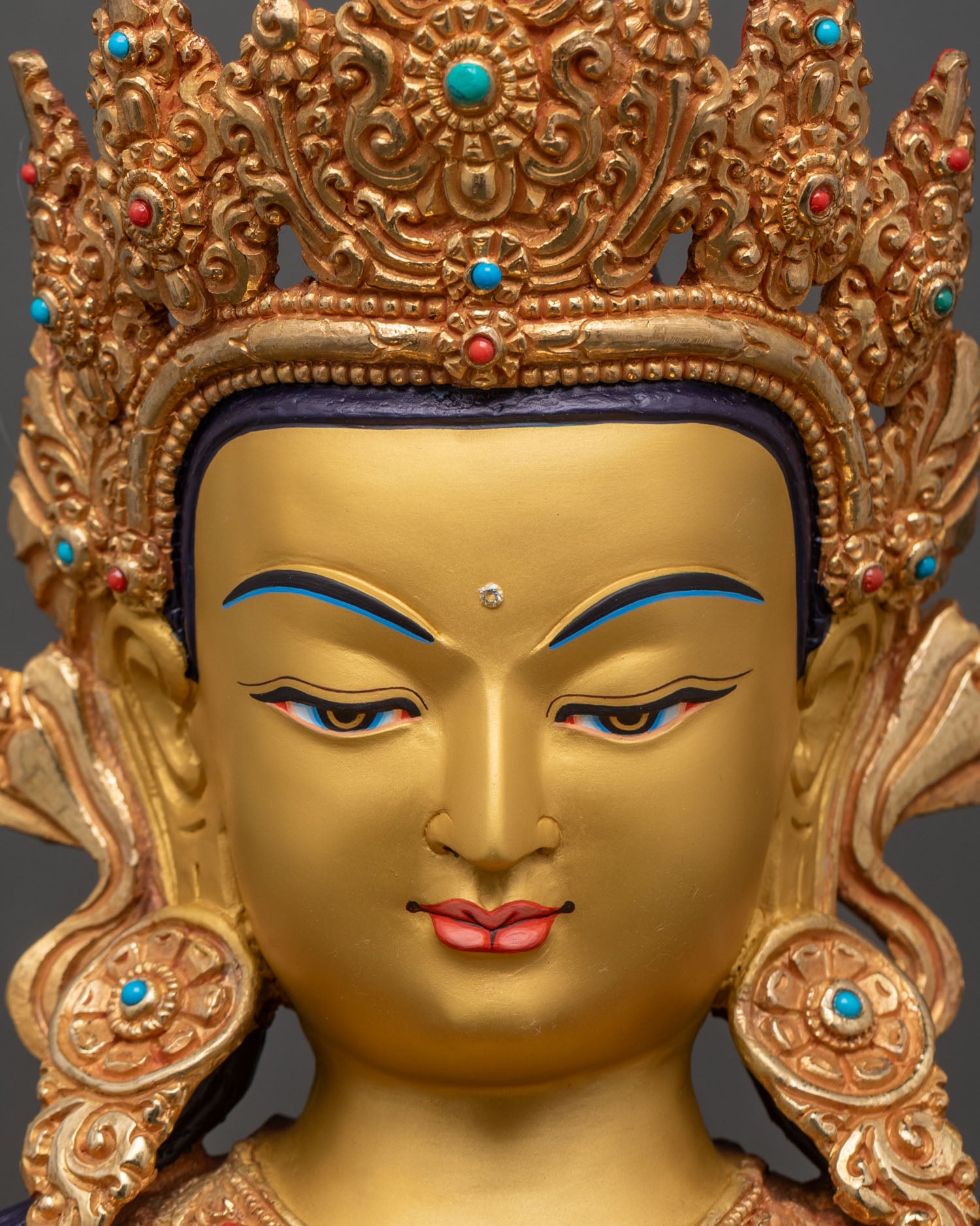 face close up of chenrezig bodhisattva with serene expression, hand painted features and gold finish