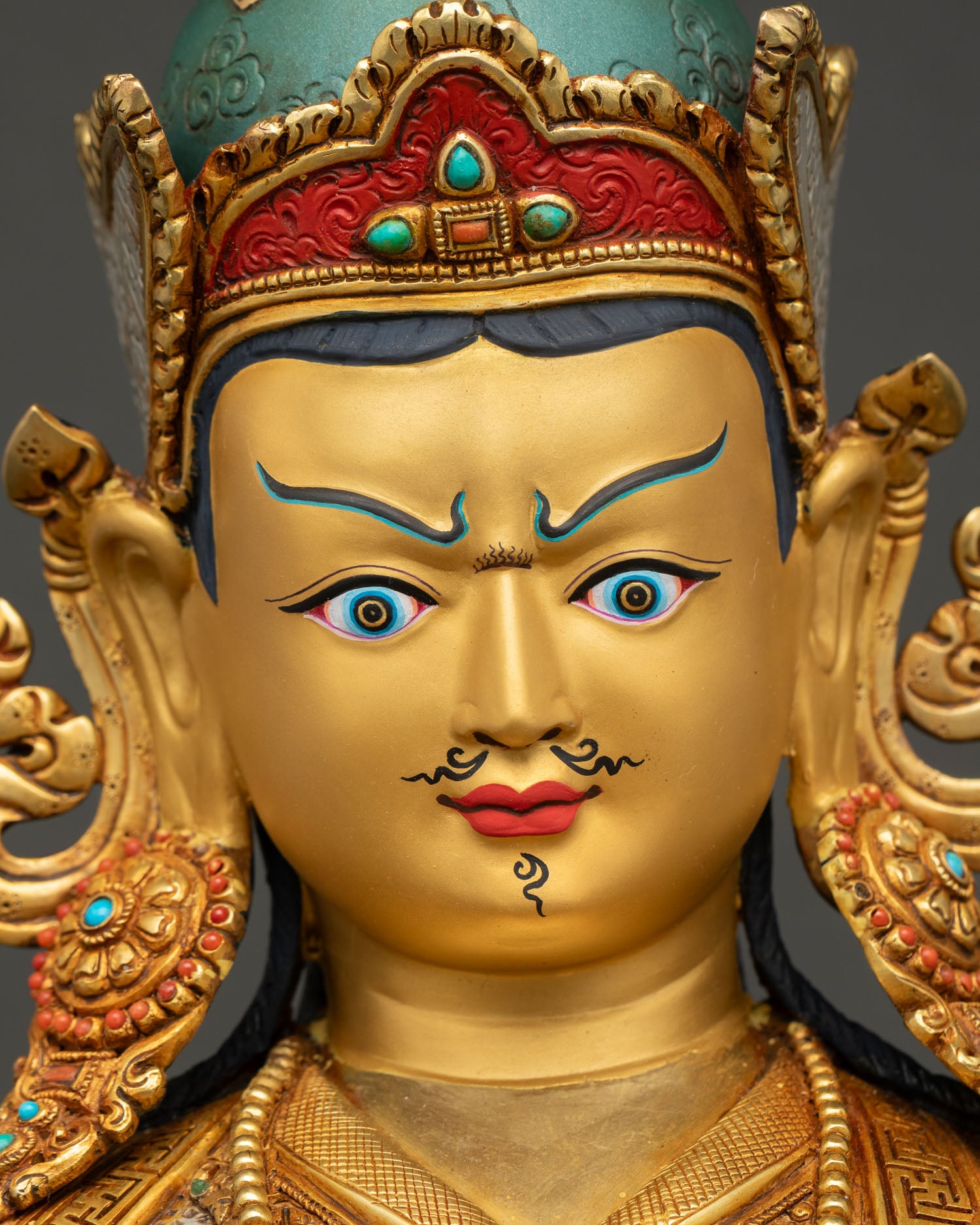 Face close up of Guru Rinpoche Statue with serene expression and hand painted features