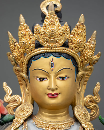 face close-up of white tara statue with peaceful gold-painted expression