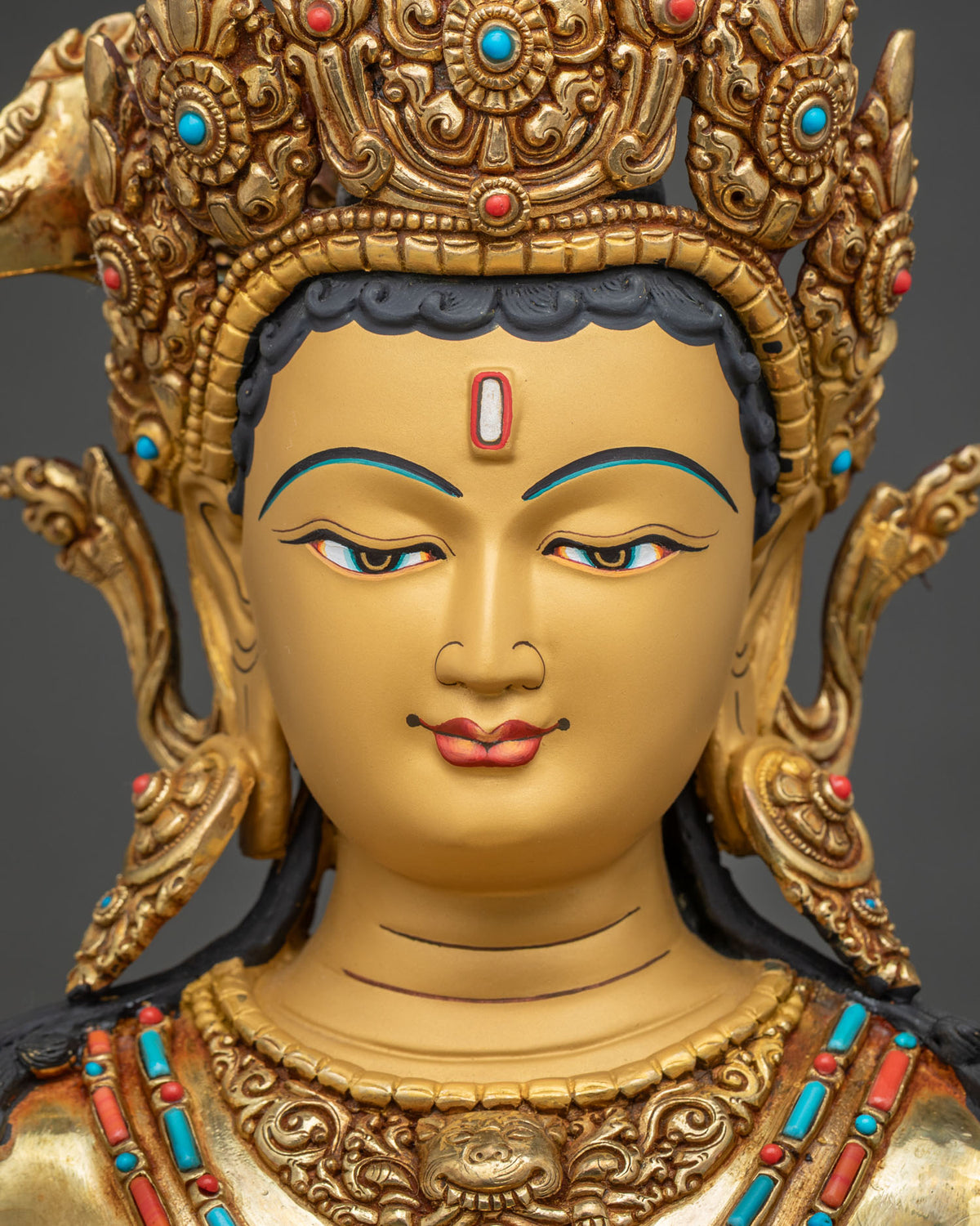 Face of Maha Manjushri statue with hand-painted eyes, jeweled crown and serene expression