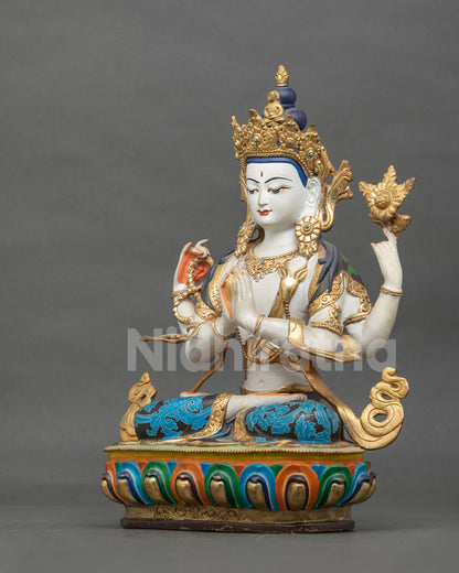 Four-armed Chenrezig statue holding a crystal rosary, lotus blossom, and wish-fulfilling jewel in four graceful arms.