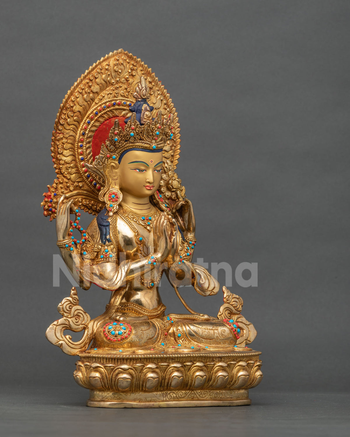 Four-armed Chenrezig statue holding mala and lotus, hands in anjali mudra