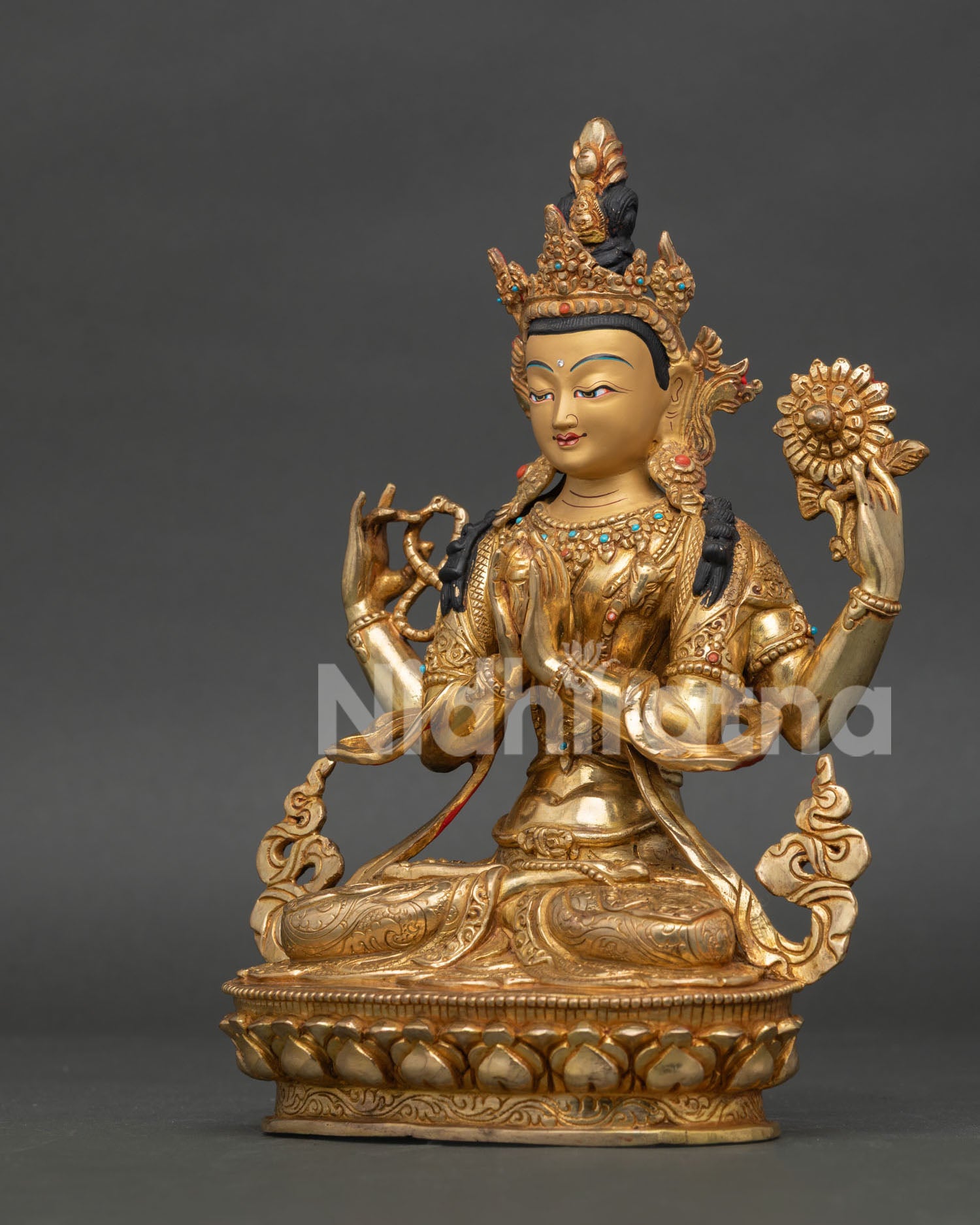 Four armed chenrezig statue holding wish fulfilling jewel mala and utpala on lotus pedestal.