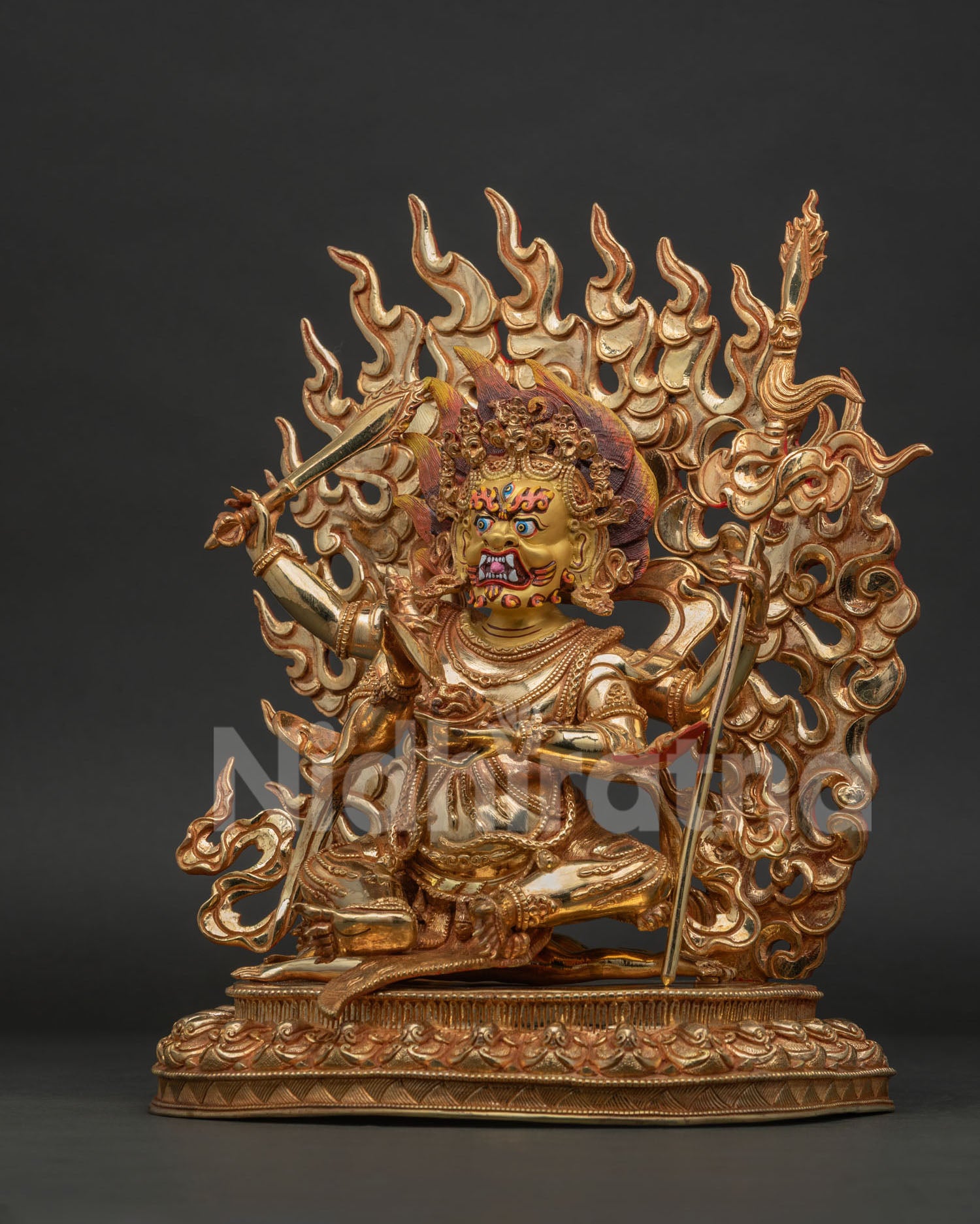 Four-Armed Mahakala seated on subdued figure atop lotus pedestal.