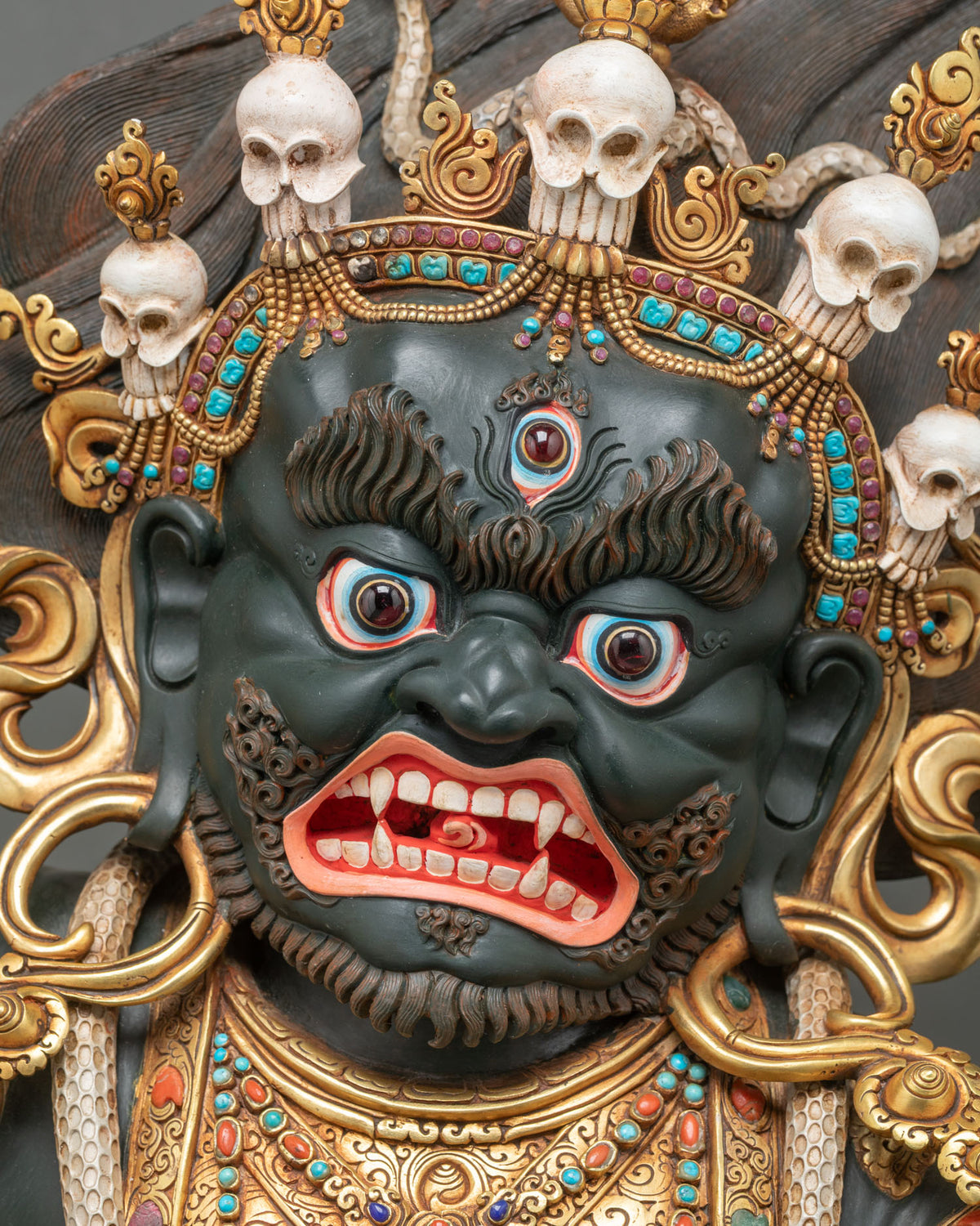 Front face of Mahakala Bernagchen with third eye, bared fangs and turquoise-set five-skull crown