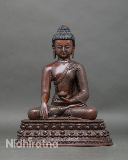 Front view of Buddha Shakyamuni statue with oxidized copper and lotus pedestal
