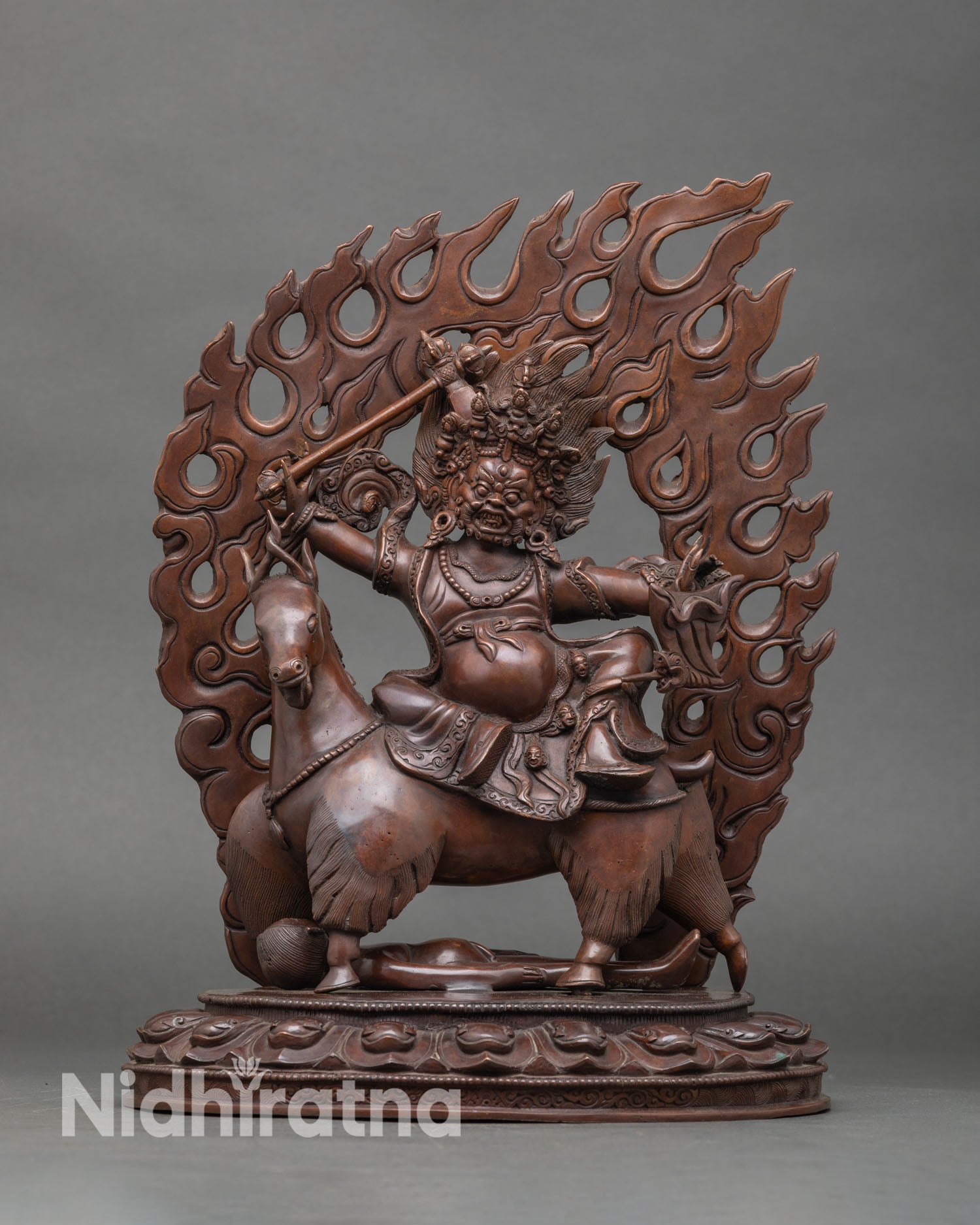 Front view of Dachhen Garwa Nagpo statue, handmade in copper, Buddhist wrathful protector deity from Nepal chemically oxidized finish seated on goat and subdued figure