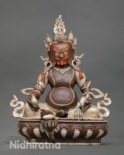 Front view of Dzambhala statue, handcrafted copper sculpture oxidized silver plated finish Newari artisan Patan Nepal wealth deity lotus pedestal