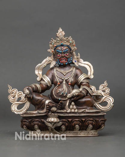 Front view of a Dzambhala statue handcrafted in oxidized silver-plated copper from Nepal.