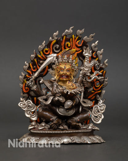 Front view of Four-Armed Mahakala statue copper oxidized silver plated finish gold painted face Nepal Newari artisan protector deity sculpture