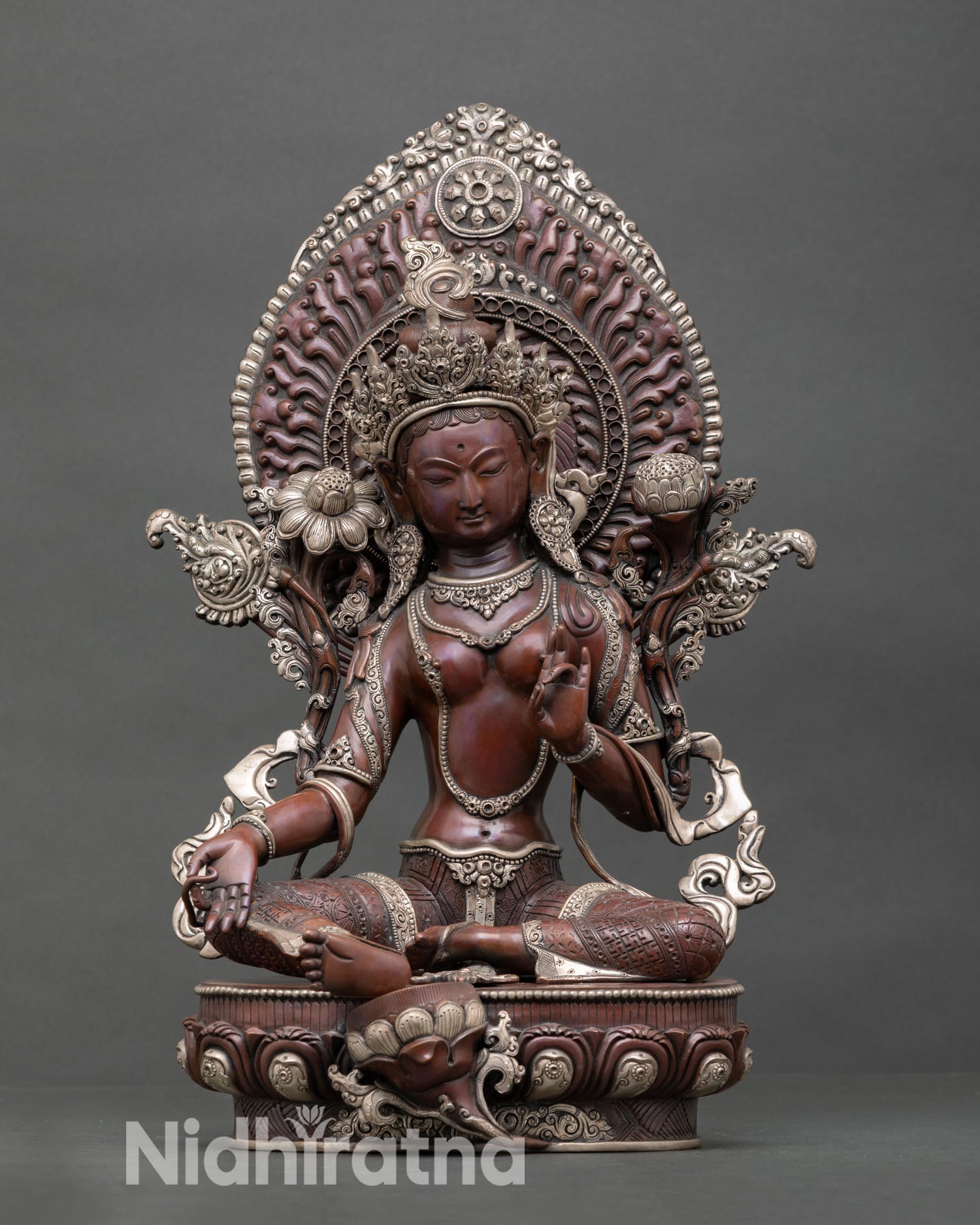 Front view of Green Tara statue handcrafted by Newari artisan from Patan Nepal oxidized copper Buddhist sculpture with silver plated detailing and lotus pedestal