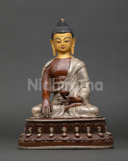 Front view of handcrafted Shakyamuni Buddha statue by Newari artisan from Patan Nepal copper oxidized silver plated finish gold painted face