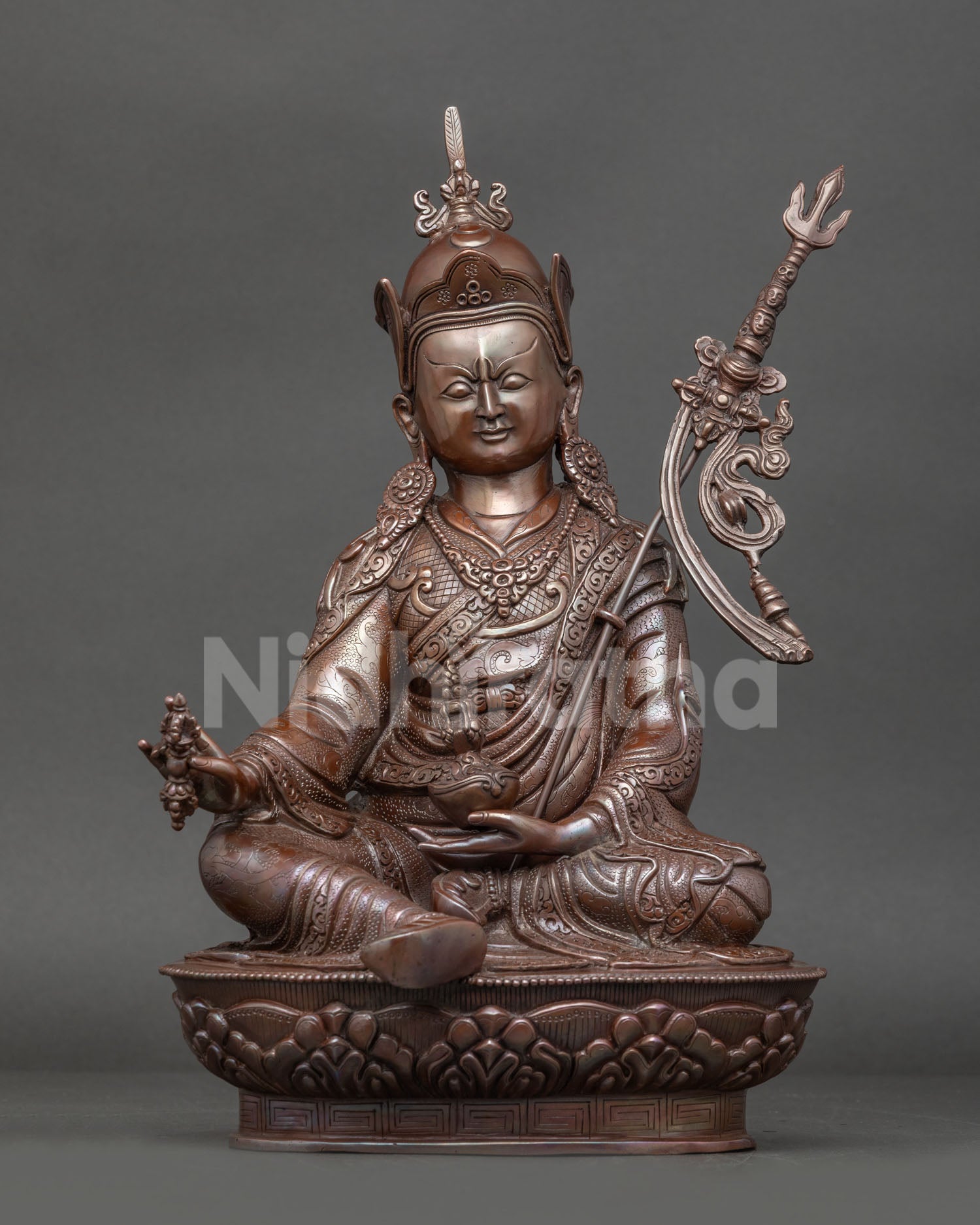 Front view of Handmade Guru Rinpoche statue in oxidized copper seated on lotus throne with vajra and skull cup trident from Nepal