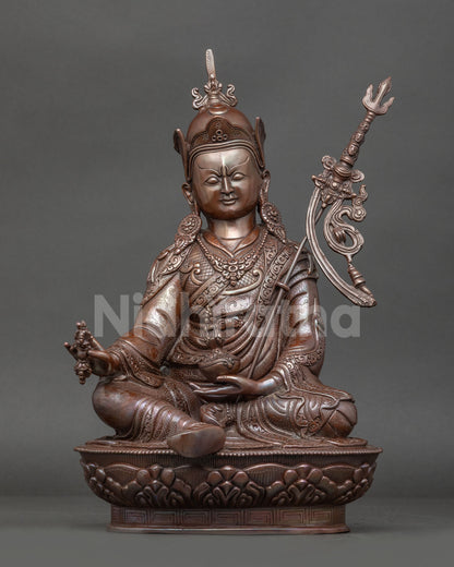 Front view of Handmade Guru Rinpoche statue in oxidized copper seated on lotus throne with vajra and skull cup trident from Nepal