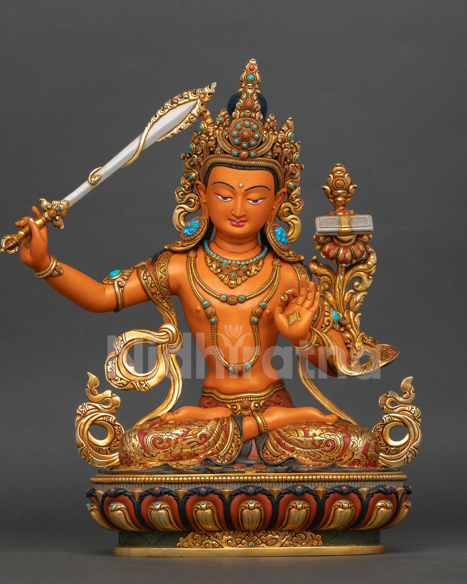 Front view of Manjushri statue, handcrafted in copper with orange hued body, 24K gold-gilding details and semi precious stones from Nepal