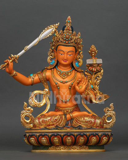Front view of Manjushri statue, handcrafted in copper with orange hued body, 24K gold-gilding details and semi precious stones from Nepal