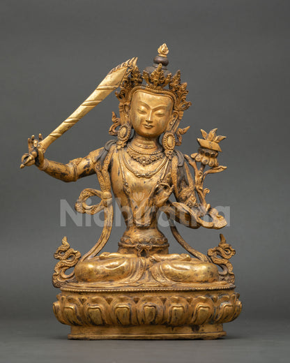 Front view of Manjushri statue handmade by Newari artist from Patan Nepal lost wax copper sculpture gold fire gilded antique finish seated on lotus pedestal