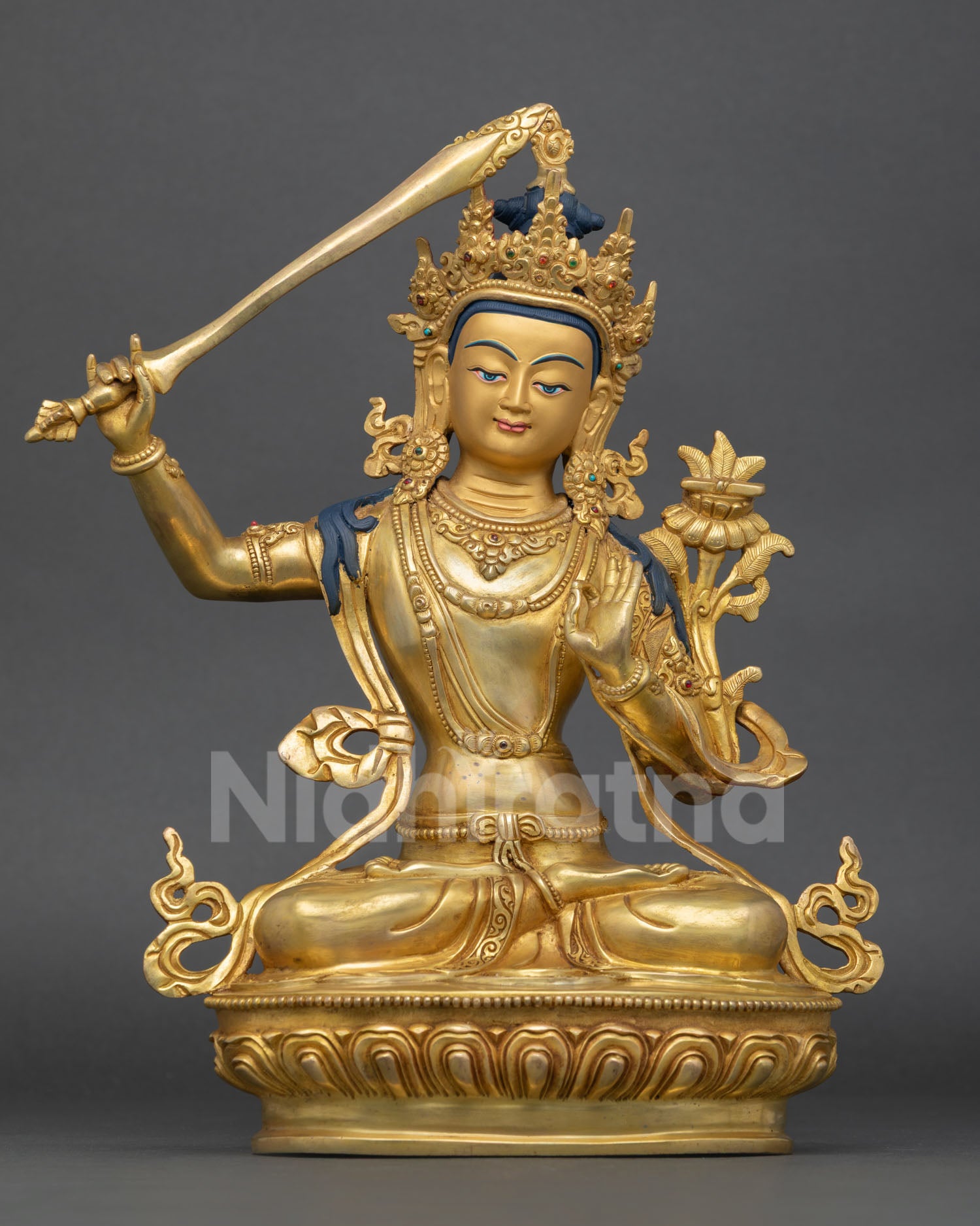 Front view of Manjushri statue with gold finish copper craftsmanship semi precious stone inlays and Himalayan Buddhist altar decor Nepal