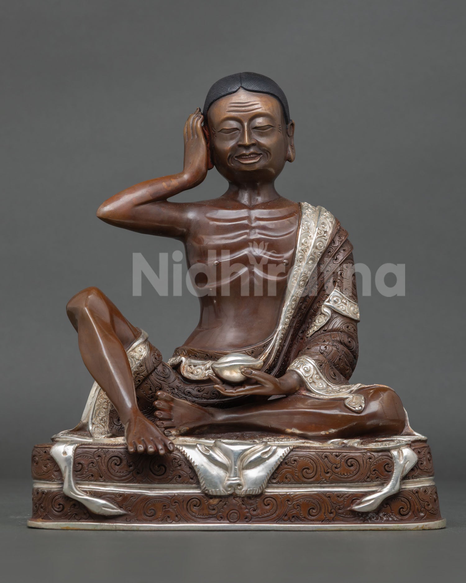 Front view of Milarepa statue, handmade in Nepal, copper oxidized and silver plated finish, seated in meditation posture