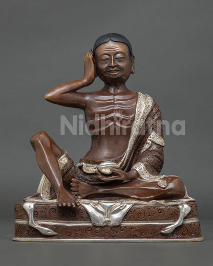 Front view of Milarepa statue, handmade in Nepal, copper oxidized and silver plated finish, seated in meditation posture
