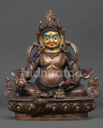 Front view of a handcrafted Dzambhala statue in oxidized copper with a beautifully gold-painted face.