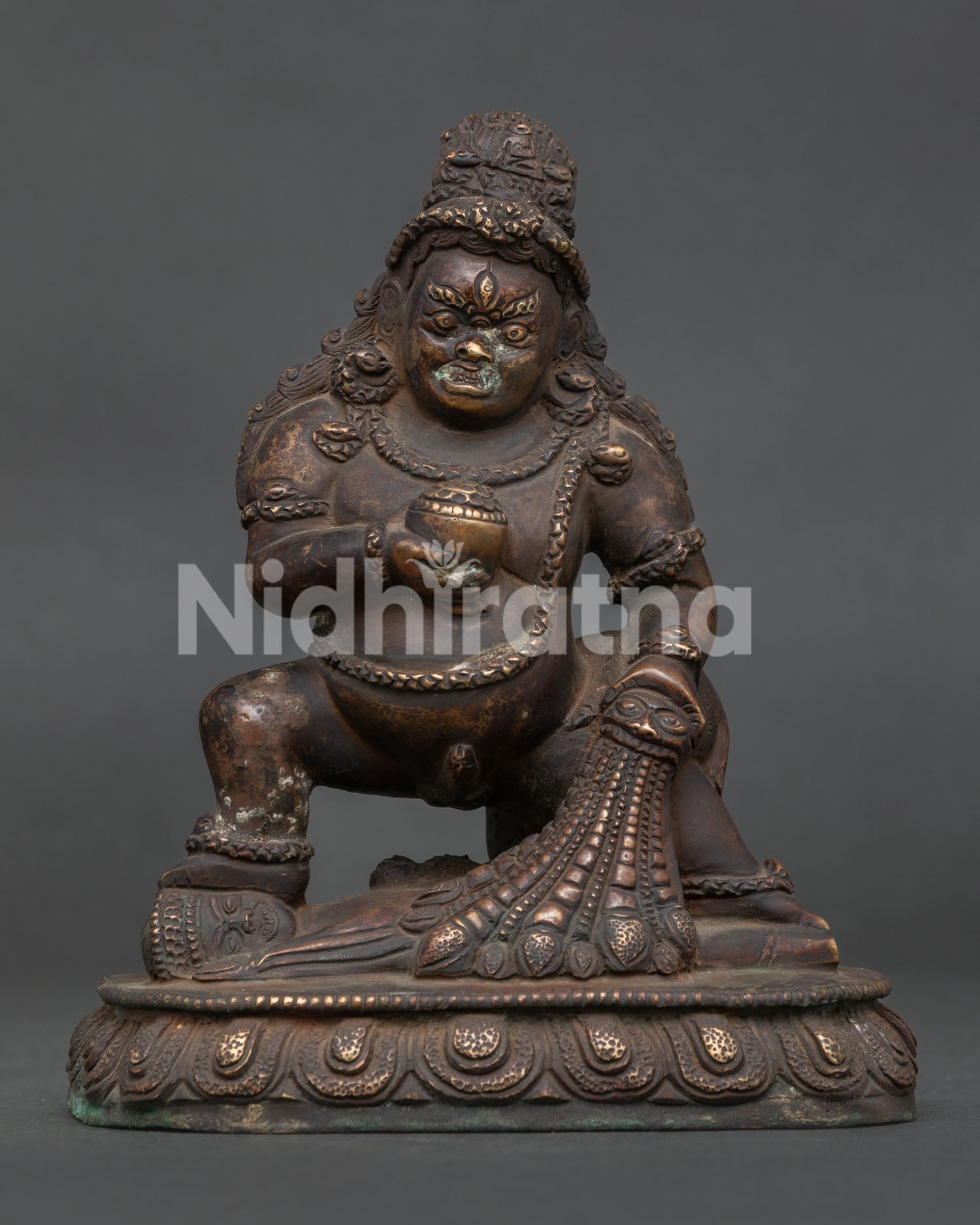 Front view of Black Dzambhala Statue with antique copper finish standing on lotus base.
