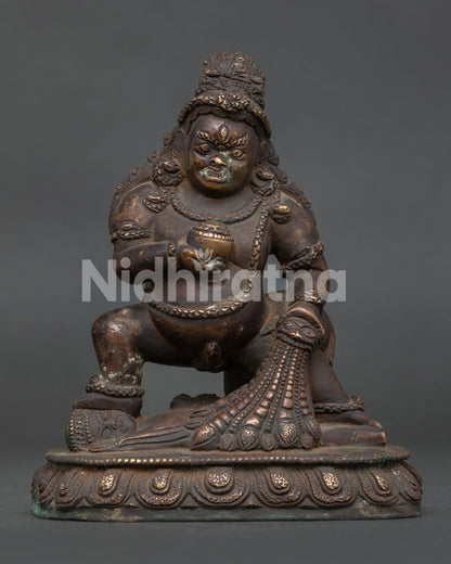 Front view of Black Dzambhala Statue with antique copper finish standing on lotus base.