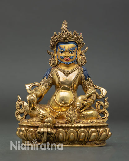 Front view of Dzambhala statue with gold painted face, copper body, and semi precious stones from Nepal.