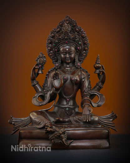 Front view of Goddess Lakshmi statue handcrafted in oxidized copper with semi precious stones and flaming halo from Nepal