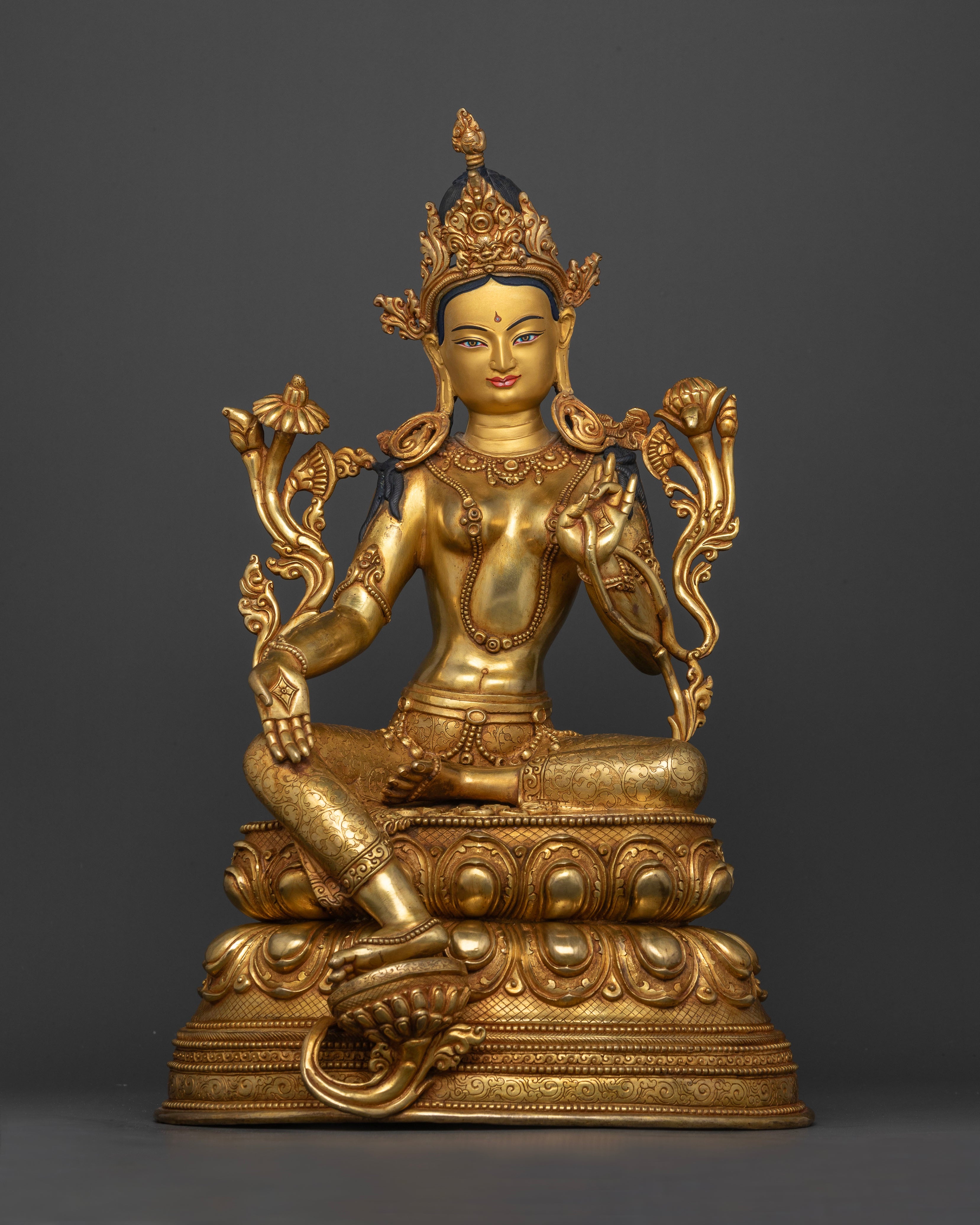 Front view of Green Tara statue, handcrafted from copper with 24K gold gilding, lotus pedestal and intricate floral motifs.