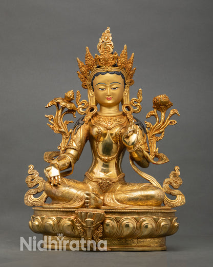Front view of Green Tara statue handcrafted in Nepal with gold fire gilded finish on lotus pedestal, Buddhist compassion deity