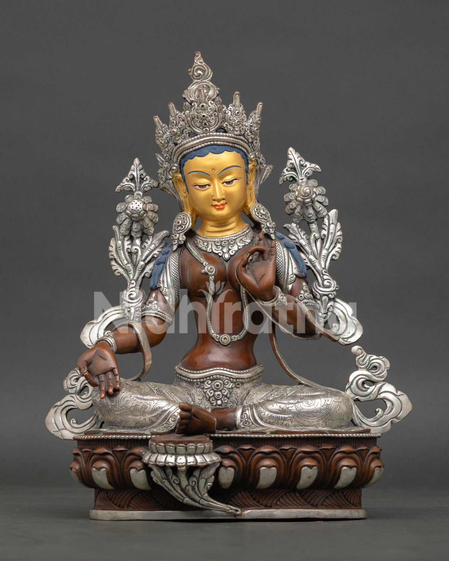 Front view of Green Tara statue handcrafted in Nepal with oxidized silver finish gold painted face and lotus throne