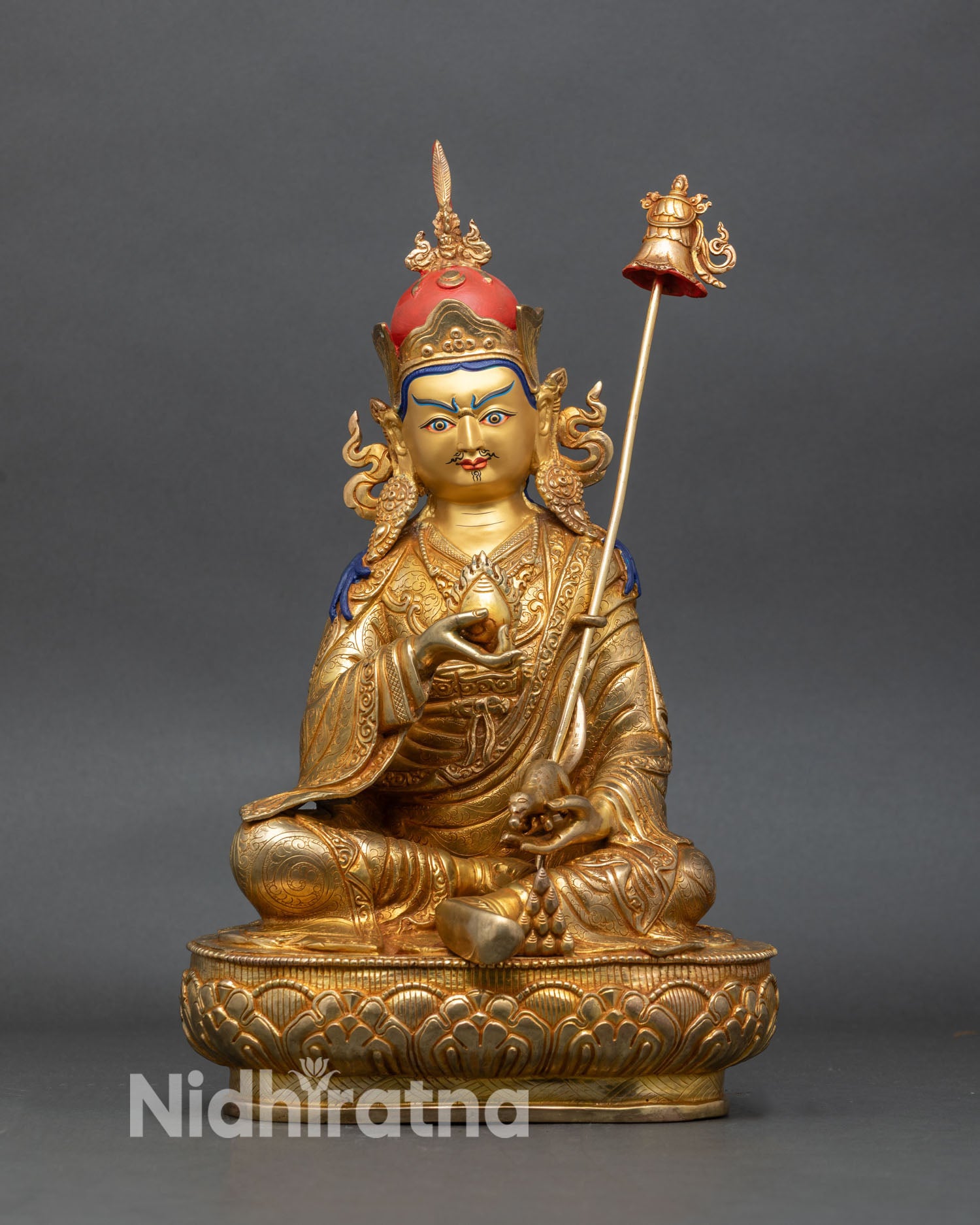 front view of guru norlha statue seated on lotus with jewel mongoose and khatvanga staff