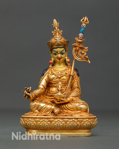 Front view of Guru Rinpoche statue handcrafted in Nepal by Newari artisans with gold gilded copper body serene gold painted face and detailed lotus seat Buddhist sculpture