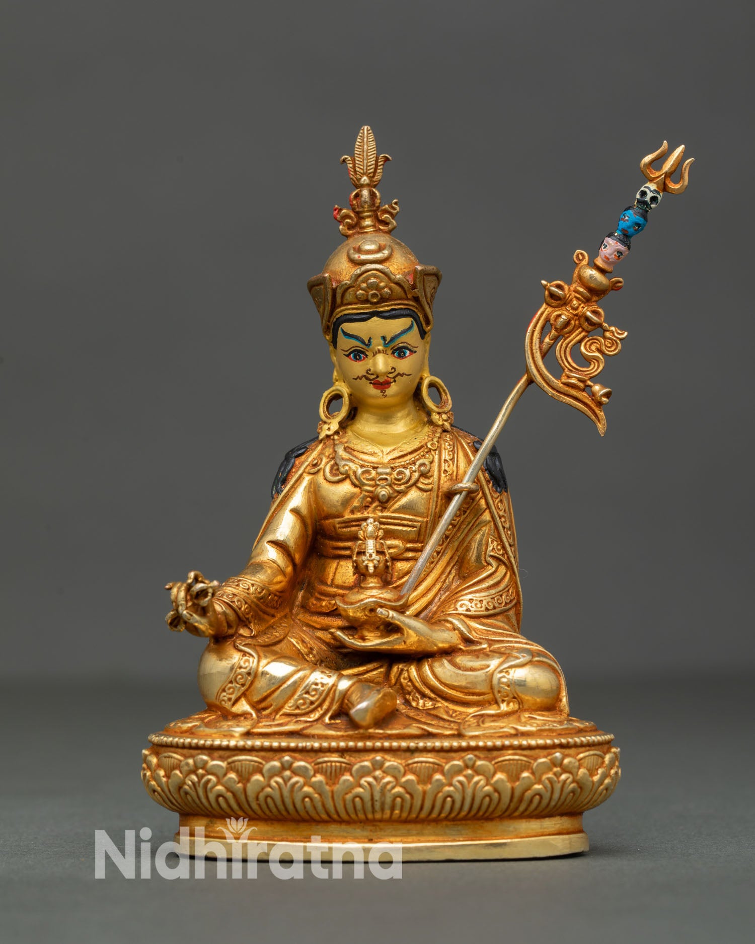 Front view of Guru Rinpoche statue handcrafted in Nepal with gold gilded copper body lotus throne elaborate hat and serene gold painted face 