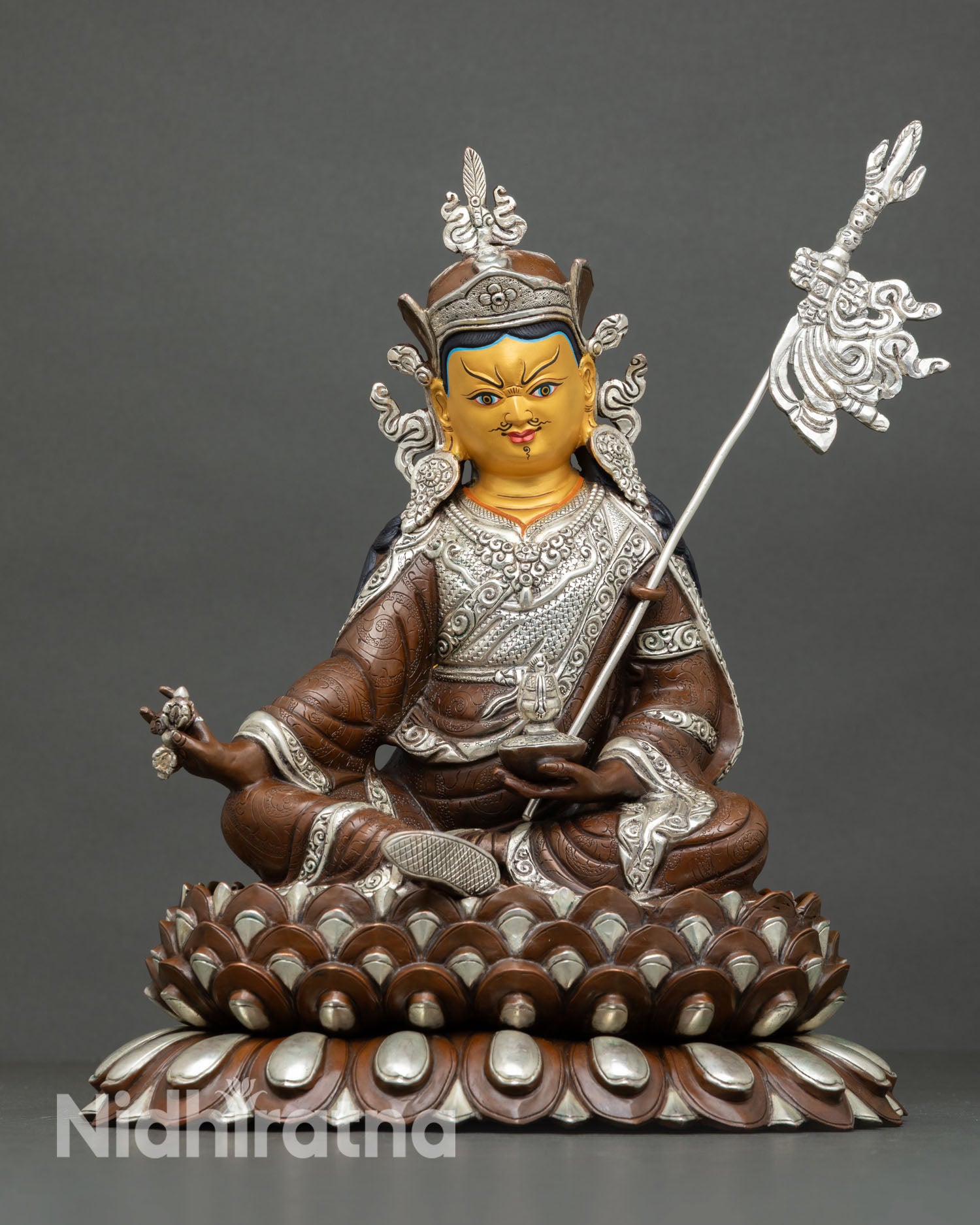 Front view of Guru Rinpoche statue handcrafted Nepalese lost wax copper sculpture with oxidized silver plated finish gold painted face and lotus seat for shrine decor