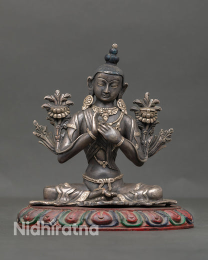 Front view of handcrafted Avalokiteshvara Chenrezig statue from Nepal in oxidized copper with silver plated jewelry seated on lotus pedestal symbolizing compassion