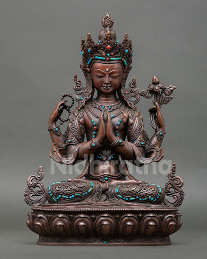 Front view of handcrafted Chenrezig statue from Nepal made in oxidized copper with turquoise and coral stones seated in serene posture symbolizing compassion