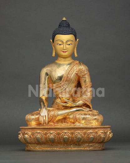 Front view of handmade Buddha Shakyamuni statue from Nepal in copper and gold fire gilding with lotus pedestal and gold-painted face