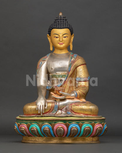 Front view of a handmade Buddha Shakyamuni statue from Nepal in copper with gold gilding, silver-plated details, and a multicolored lotus pedestal with a gold-painted face
