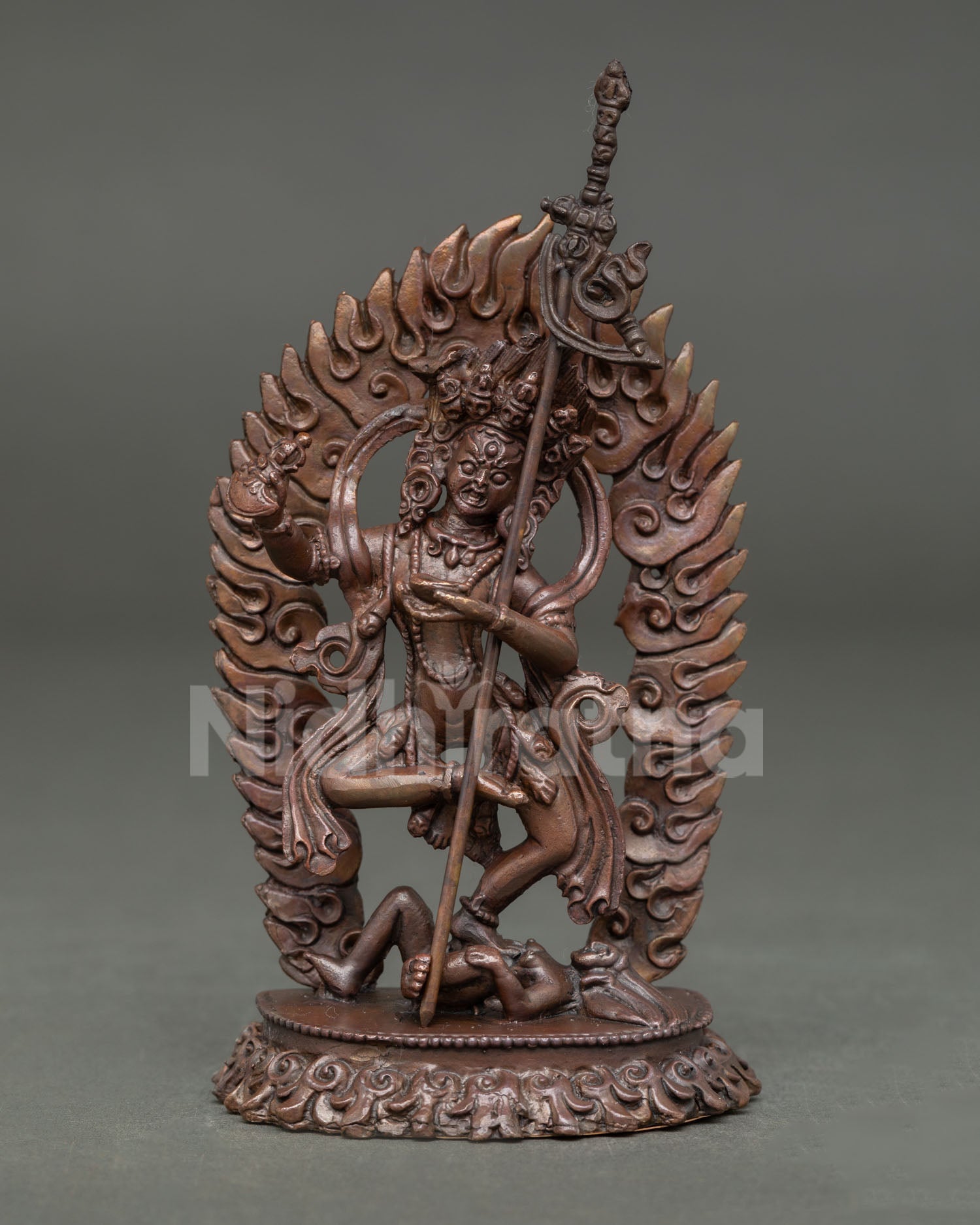Front view of handmade Dorje Phagmo statue in oxidized copper standing on a subdued figure with flaming halo