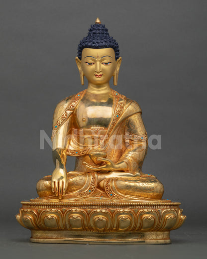 Front view of Handmade Shakyamuni Buddha statue seated on lotus pedestal in copper with gold gilding and turquoise stone embellished monastic robe